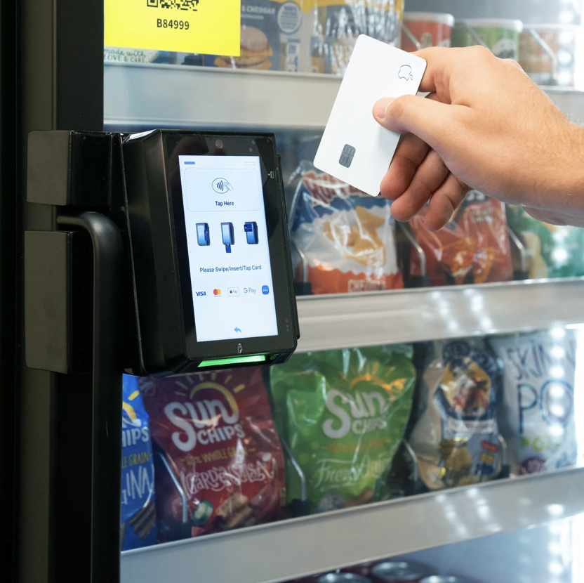 Customer tapping contactless payment card on Grabbix smart vending machine